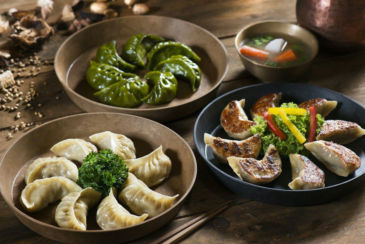 Plates of dumplings with dipping sauces